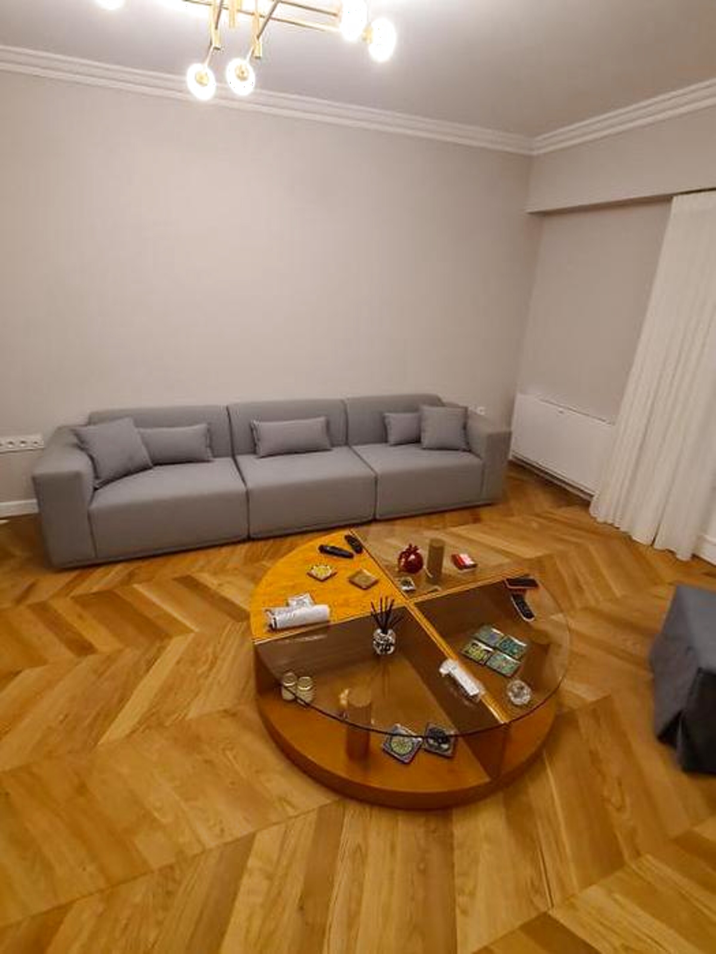 Μοντέρνος γκρι modular καναπές σε σαλόνι με ψαροκόκαλο πάτωμα